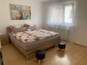 1 dormitorio con 1 cama con 2 taburetes en Schwarzwaldmarie, en Bühl