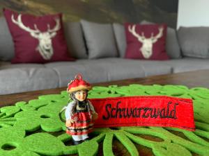 a small figurine of a doll sitting on a table at Schwarzwaldmarie in Bühl