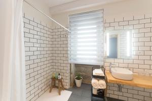 La salle de bains blanche est pourvue d'un lavabo et d'un miroir. dans l'établissement Luz de Viro, à Outes