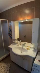 a bathroom with a sink and a mirror at Aristoteles Apartments in Olympiada +1 photo