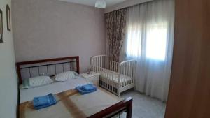 奧林匹亞達的住宿－Aristoteles Apartments，一间卧室设有两张双床婴儿床和一扇窗户。