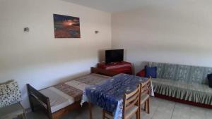 a room with a table and chairs and a couch at Aristoteles Apartments in Olympiada