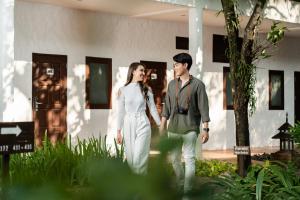 a man and a woman standing in front of a building at The Legend Chiang Rai Boutique River Resort & Spa - SHA Extra Plus in Chiang Rai