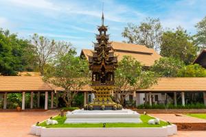 un gran monumento frente a un edificio en The Legend Chiang Rai Boutique River Resort & Spa - SHA Extra Plus en Chiang Rai