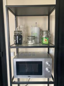 a microwave on a shelf in a kitchen at L'INTEMPOREL - A 300m de la gare de Tours in Tours