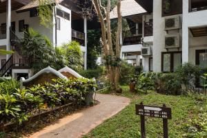 un cartel frente a un edificio con jardín en The Legend Chiang Rai Boutique River Resort & Spa, en Chiang Rai