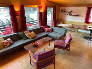 a living room with a blue couch and purple chairs at La Civetta (714 La) in Valbella