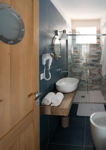 ein Bad mit einem Waschbecken und einer Glasdusche in der Unterkunft Dame del Mare in Castro di Lecce