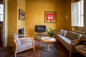 a living room with a couch and a tv at Masia Can Comas in San Pedro de Riudevitlles