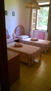 two beds in a room with two tables and a window at B&B Villa Anna Wunderbar in Ischia