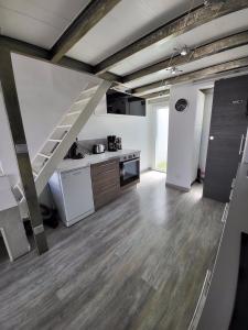 an open kitchen and living room with wooden floors at Studio mezzanine Saint Bres. 20min de Montpellier in Saint-Brès