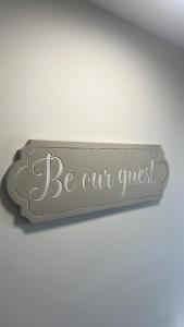 a sign that says be our guest on a wall at Westland Suites - Stylish, Modern, Elegant, Central Apartments A in Derry Londonderry
