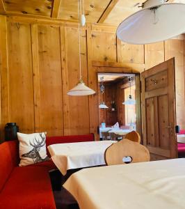 um quarto com duas camas e um sofá vermelho em Pension Dangl - Glacier Rock em Solda