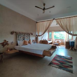 a bedroom with a large bed and a living room at Matsya in Havelock Island