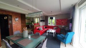 ein Wohnzimmer mit einem roten Sofa und blauen Stühlen in der Unterkunft Dom na Leszczynowej Górce - plaża, las in Lyck