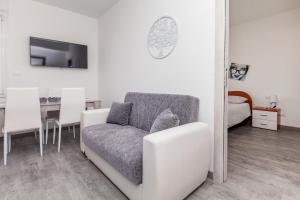 uma sala de estar com um sofá e uma mesa em E-Bicocca em Milão