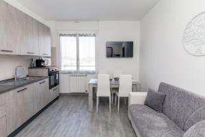 uma cozinha e sala de estar com um sofá e uma mesa em E-Bicocca em Milão