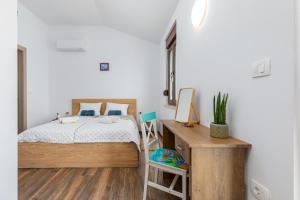 mała sypialnia z łóżkiem i biurkiem w obiekcie Rental house Nada w Fažanie