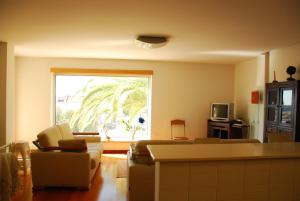 - un salon avec un canapé, des chaises et une fenêtre dans l'établissement AH Leiria apartment, à Leiria