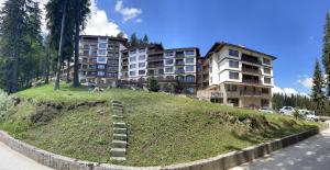 a building on top of a hill next to a street at Complex Nero in Pamporovo