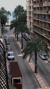 Blick auf eine Straße mit Palmen und ein Gebäude in der Unterkunft Cullera Mar y Montaña in Cullera