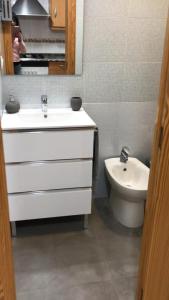 ein Badezimmer mit einem weißen Waschbecken und einem WC in der Unterkunft Cullera Mar y Montaña in Cullera