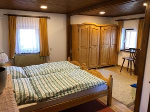 ein Schlafzimmer mit einem Bett und einem Holzschrank in der Unterkunft Foidlhaus in Bierbaum am Auersbach