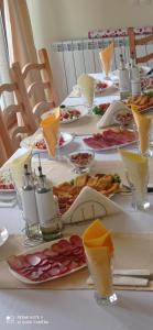 una mesa larga con platos de comida. en Хотел-ресторант Русаков en Sandanski