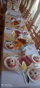 una mesa larga con platos de comida. en Хотел-ресторант Русаков en Sandanski