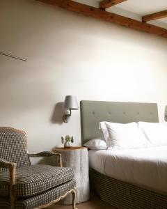 ein Schlafzimmer mit einem Bett und einem Stuhl in der Unterkunft LA OTRA KASA in Alameda del Valle