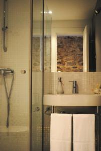 a bathroom with a shower and a sink with towels at LA OTRA KASA in Alameda del Valle