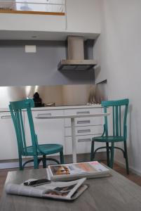 a kitchen with two green chairs and a table at LA OTRA KASA in Alameda del Valle