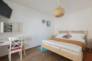a bedroom with a bed and a desk and a chair at La casa di Nonno in Milna