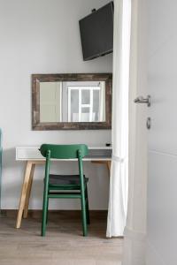 a green chair sitting at a desk with a mirror at La casa di Nonno in Milna
