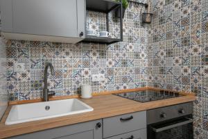 a kitchen with a sink and a tile wall at La casa di Nonno in Milna +55 photos