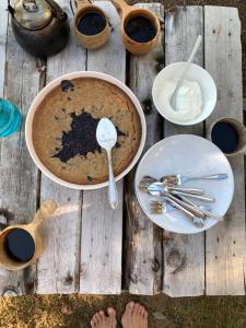 a table with a cake and spoons and dishes on it at Metsä Kolo in Saariharju