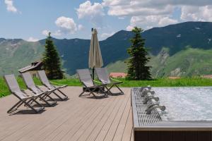 a group of chairs and a pool with a umbrella at Gudauri Lodge in Gudauri
