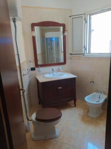 La salle de bains est pourvue de toilettes, d'un lavabo et d'un miroir. dans l'établissement Estìa Casa Vacanze, à Scilla
