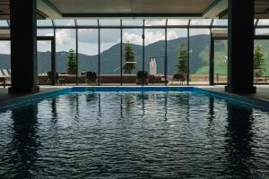a swimming pool in a building with a view of the mountains at Gudauri Lodge in Gudauri