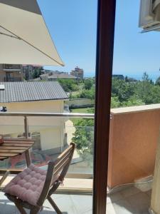 a balcony with a chair and a table and an umbrella at Perla 1 apartments in Ravda
