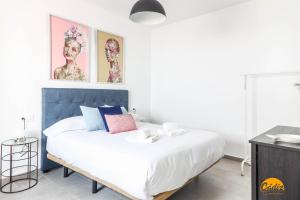 een slaapkamer met een groot wit bed met een blauw hoofdeinde bij Casa Rehala by Cadiz Time in Cádiz