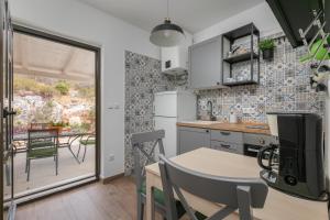 a kitchen and dining room with a table and chairs at La casa di Nonno in Milna
