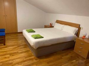 a bedroom with a bed with two green towels on it at Casa del Puente - MurallaHomes in Ávila