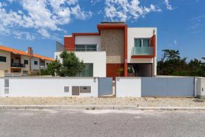 una casa con vallas blancas frente a una calle en O Cantinho Entre a Ria e o Mar, en Torreira