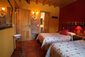 a hotel room with two beds and a door at Casa rural El Leñador in Muñana