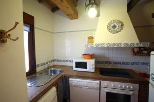cocina con fregadero y microondas en Casa rural El Leñador en Muñana