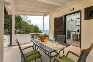 a table and chairs on a balcony with the ocean at La casa di Nonno in Milna