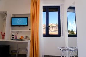 TV i/ili multimedijalni sistem u objektu L'Orologio Guest Rooms