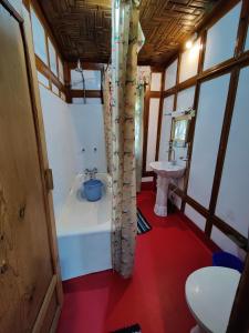 a small bathroom with a tub and a sink at Shiraz Deluxe Houseboat in Srinagar