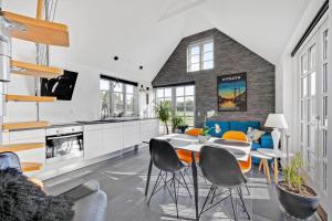 a kitchen and living room with a table and chairs at Lildgaard in Frøstrup